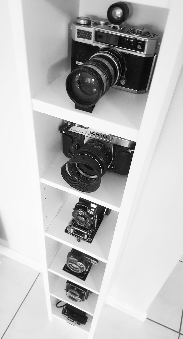 black and white photograph of cameras on shelves