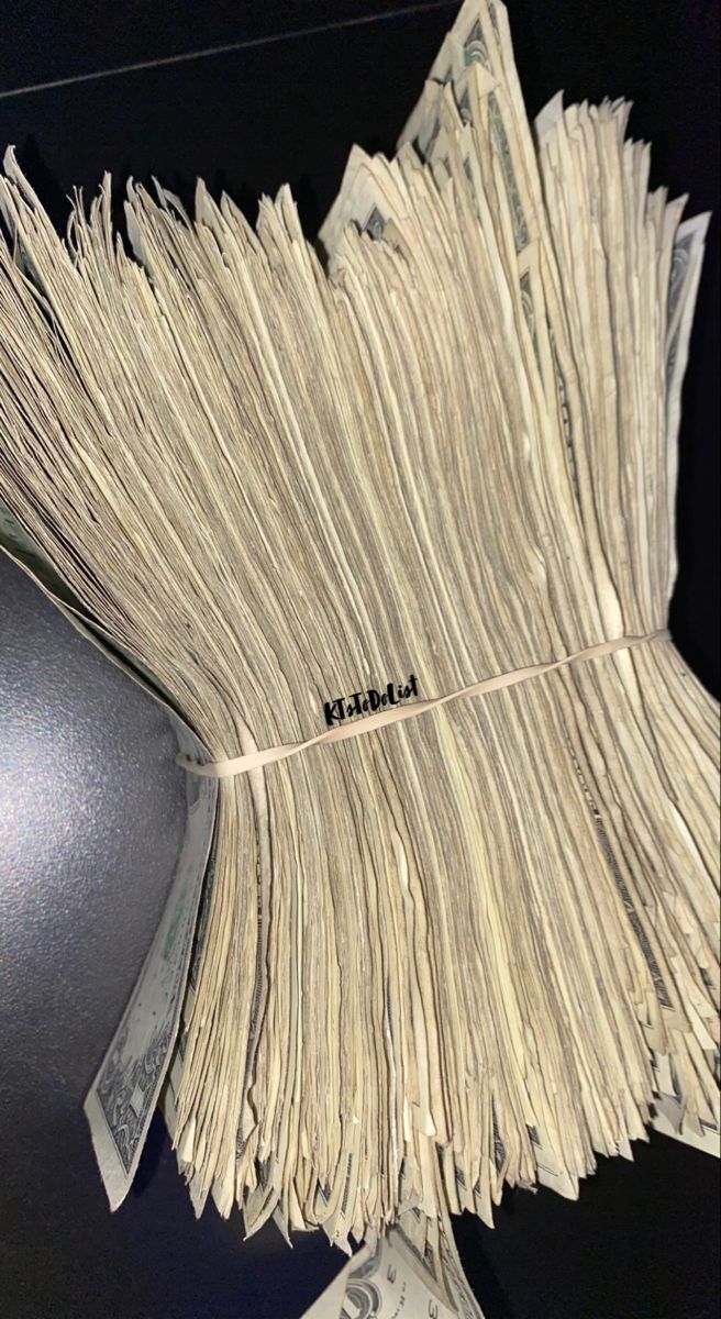 a pile of money sitting on top of a computer keyboard