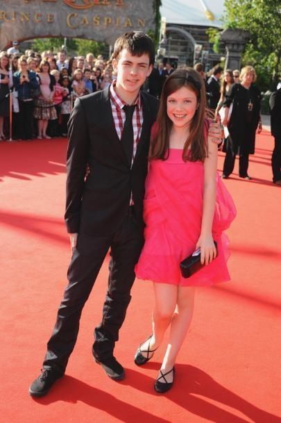 two people standing on a red carpet at an event