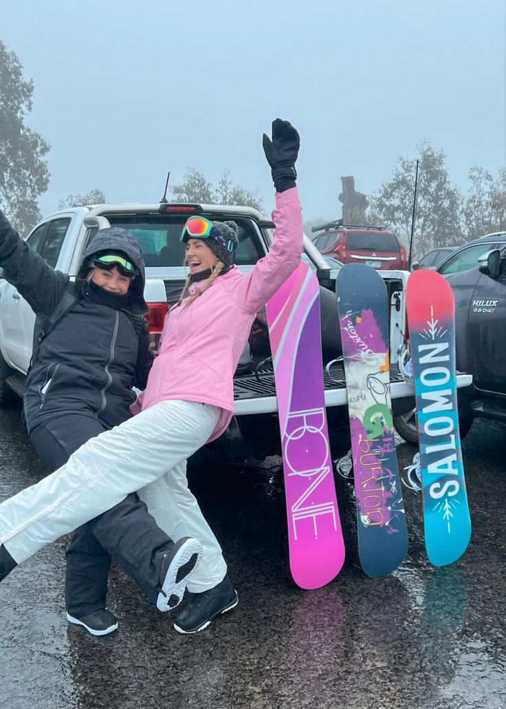 two people with snowboards in the back of a truck