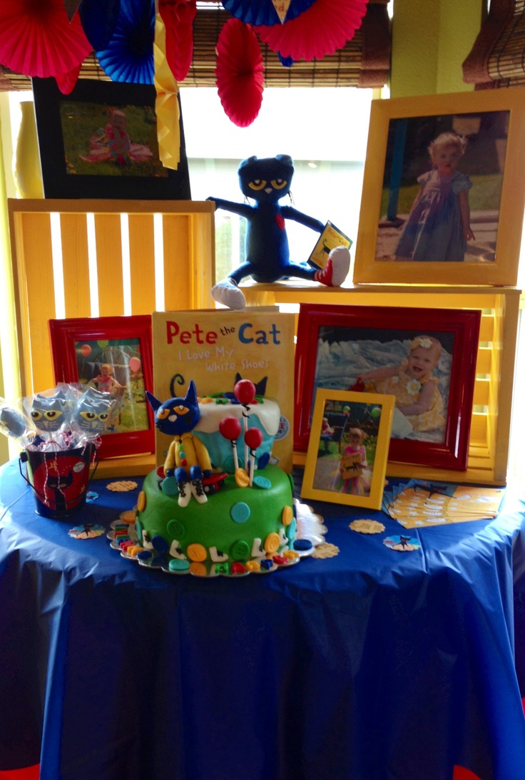 there is a cake on the table with pictures in front of it and an image of pete the cat