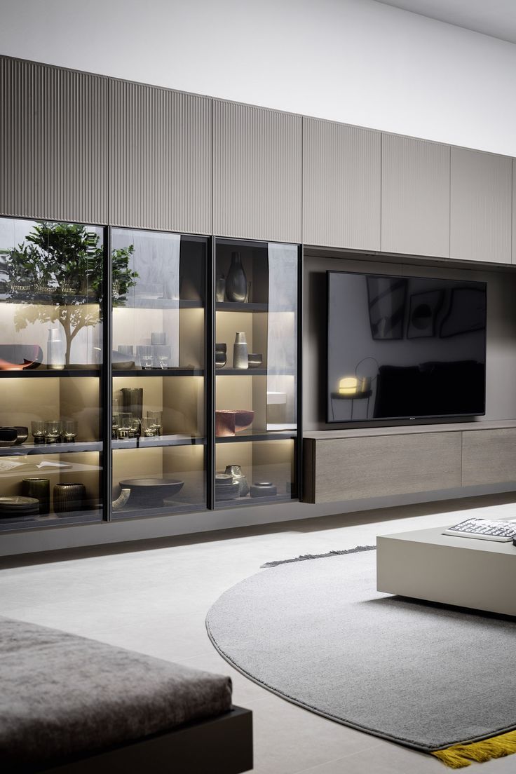 a modern living room with large windows and a flat screen tv mounted on the wall