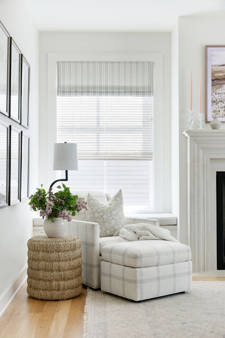 a living room with a couch, chair and fire place in the corner next to a window