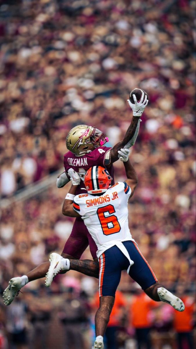 two football players are jumping in the air