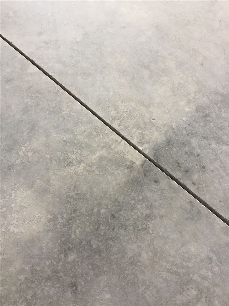 a red and white fire hydrant sitting on top of a cement floor