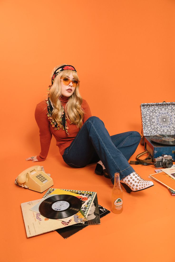 a woman is sitting on the floor with her legs crossed and headphones in her ears