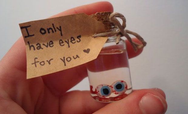 a hand holding a tiny bottle with eyeballs in it that says i only have eyes for you