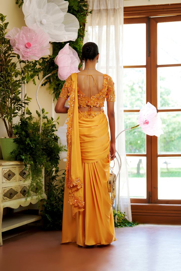 Letting it flow for this season is the way to go. This flowy pre-draped saree is made for everyone who wants to be comfortable at their soirees. The trail of the saree is embellished with flowers so that you can leave your sparkle everywhere you go. Blouse with embroidered sleeves and the sleek shine of the satin fabric on the chest. hook at the back of the blouse. A pre-draped saree with a comfortable fit comes with an embroidered waistline. a concealed zip at the back of the saree From Moledro Draped Saree, Butterfly Net, Open Image, Let It Flow, Drape Saree, Embroidered Sleeves, Way To Go, The Trail, Satin Fabric