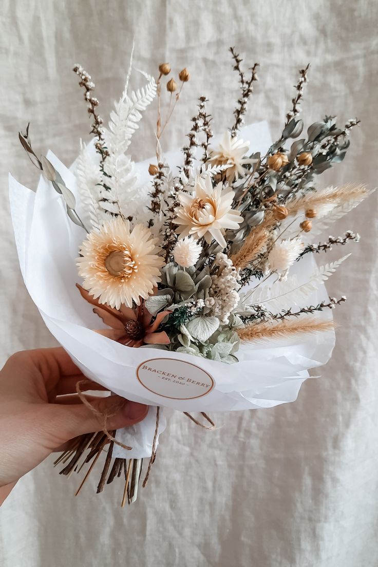 a person holding a bouquet of flowers in their hand