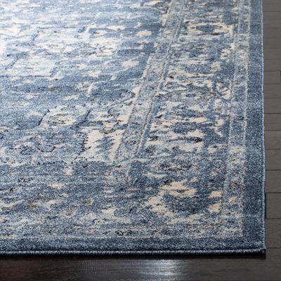 a blue and white rug on top of a wooden floor