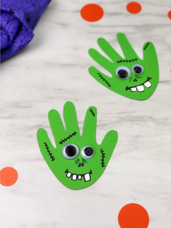 two green handprints with googly eyes on them