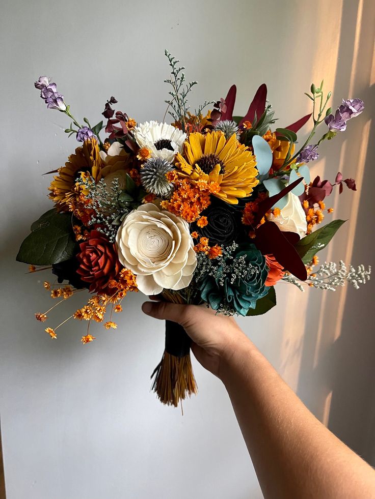 a person holding a bouquet of flowers in their hand