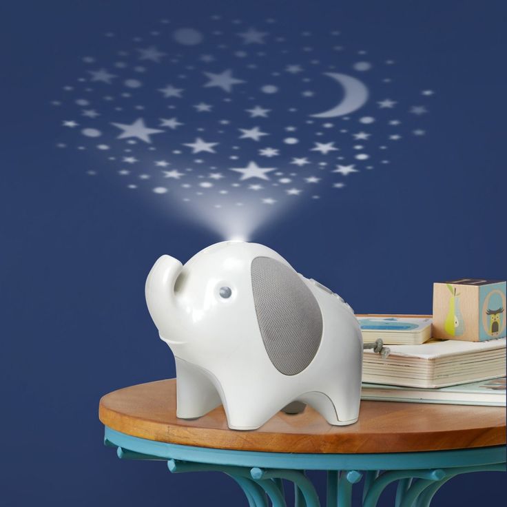 an elephant night light sitting on top of a table next to books and a book