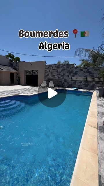 a pool with blue water in front of a house and the words goumenedes algeria on it