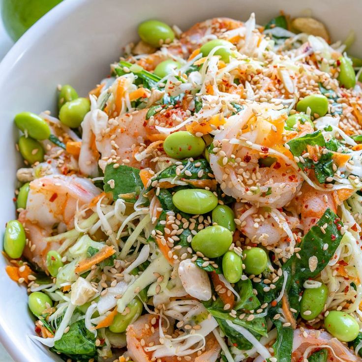 a white bowl filled with vegetables and shrimp