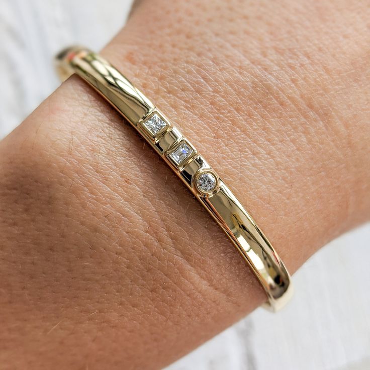 "Our modern 3-stone diamond cuff bracelet features square, emerald and round diamonds set in the middle of a thick, solid gold band. This beautiful bracelet is completely customizable. You can change the diamond shapes, replace diamonds with colored gemstones, change the width, etc. Contact us today with your design idea and for a quote: http://etsy.me/1231fkN Details: - Made at our family-run studio in NYC. - Choose from 14k ,18k (yellow, rose, white Gold) or Platinum. - Solid 14k, 18k yellow, 14k Gold Bangle With Diamond Accents For Everyday Luxury, Channel Set Diamond Bracelet For Anniversary, Modern Channel Set Diamond Bracelet For Anniversary, Anniversary Diamond Bracelet Channel Set, Timeless Wedding Cuff Bracelet With Single Cut Diamonds, Modern Diamond White Jewelry Channel Set, Modern Princess Cut Single Diamond Jewelry, Luxury Diamond Bracelet With Bezel Setting As Gift, Modern Diamond Bracelet As A Gift