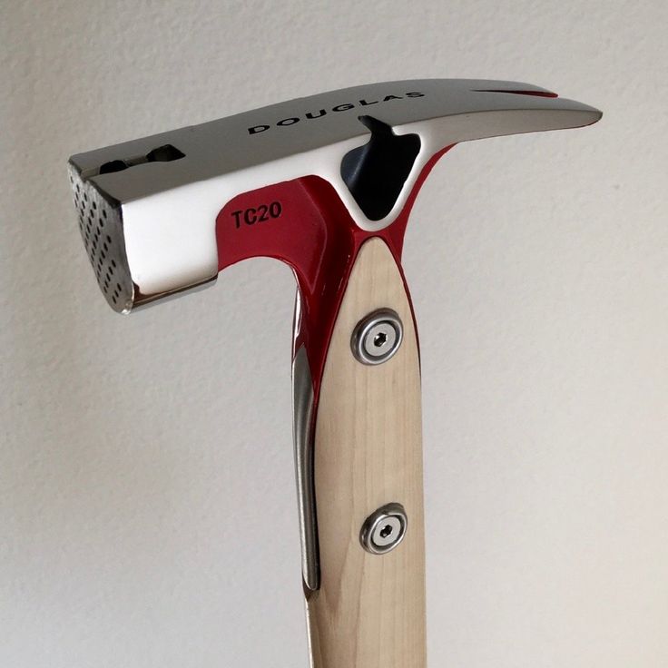 a red and white razor blade on top of a wooden handle with holes in it