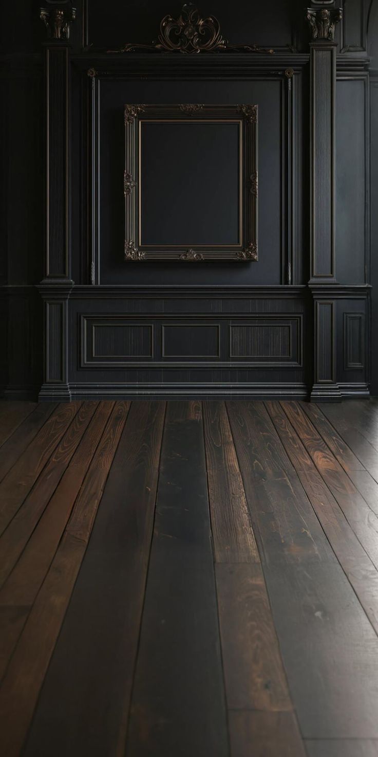 an empty room with black walls and wooden floors