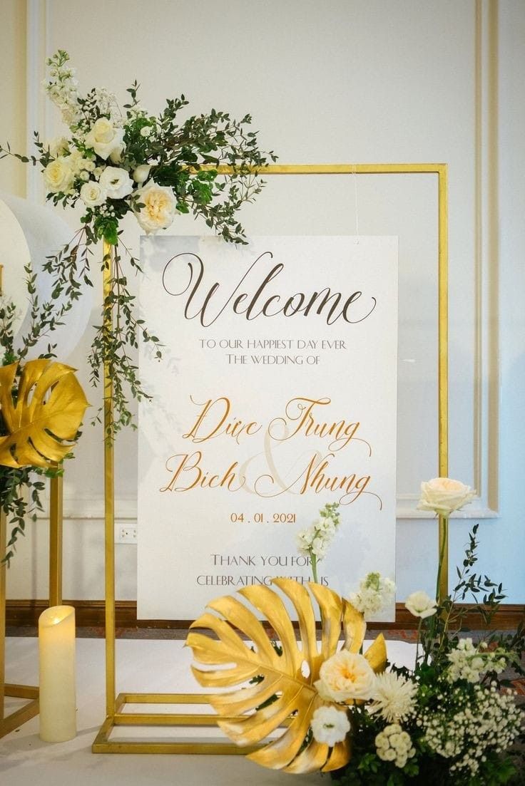 a welcome sign with flowers and candles in front of it