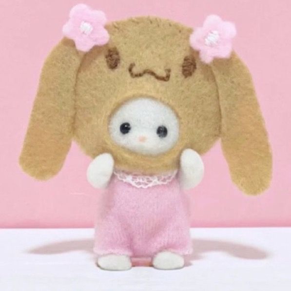 a small stuffed animal wearing a pink dress with flowers on it's head and ears