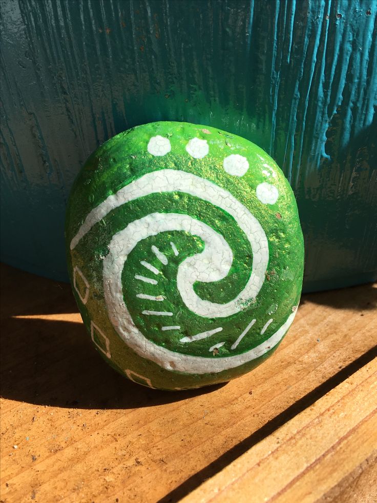 a green and white rock sitting on top of a wooden table