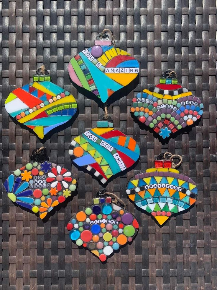 several pieces of colorful glass sitting on top of a wicker table next to each other