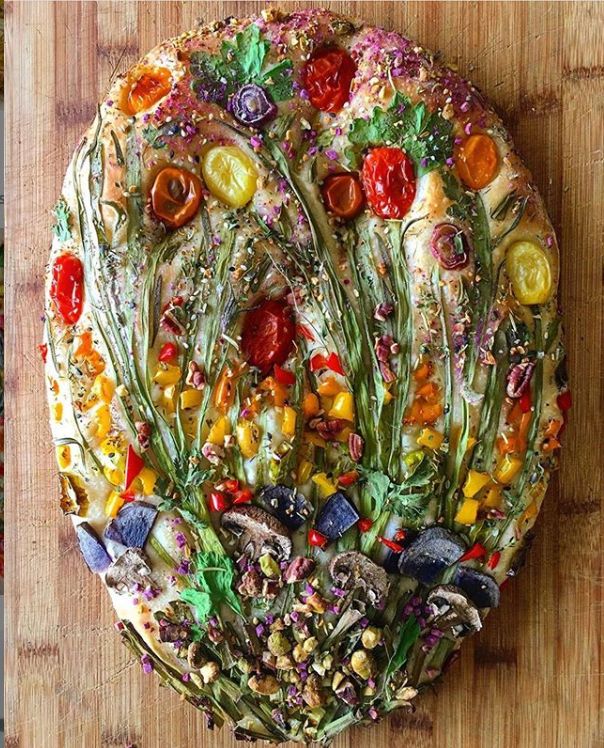 a pizza covered in lots of different types of toppings on top of a wooden table