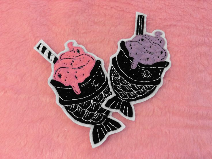 two fish with hats and scarfs on pink fur