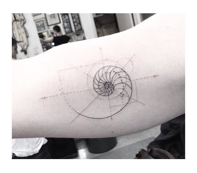 a person's arm with a tattoo on it that has an image of a spiral