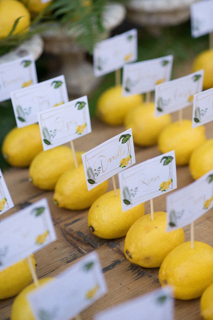 lemons are lined up on the table with place cards for each individual to put on them