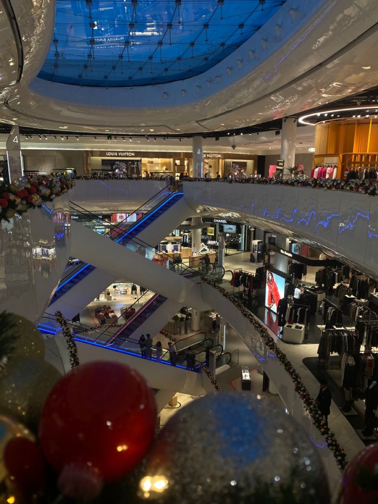 the interior of a shopping mall with christmas decorations and lights on it's ceiling