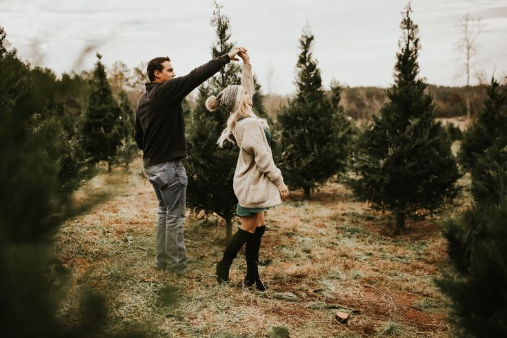 a man and woman picking out christmas trees