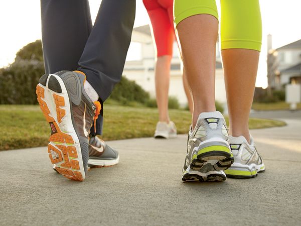 there are three people walking down the street with their feet on each other's legs