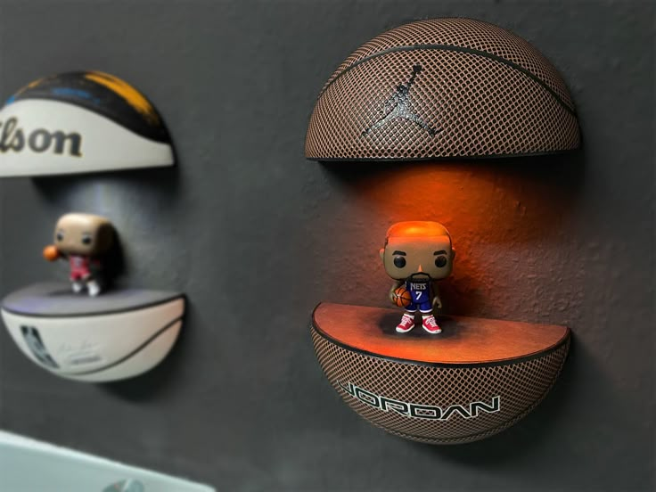 three basketball themed shelves on the wall with figurines sitting on top of them