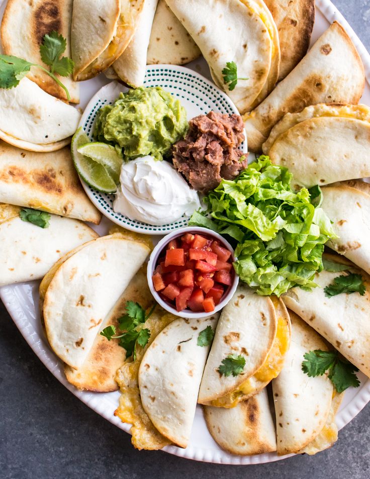 tortillas with salsa, guacamole and sour cream on a plate