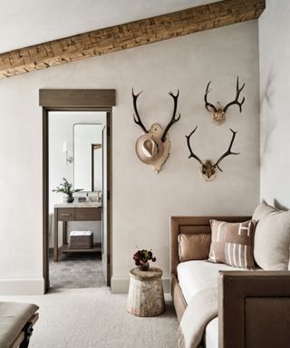 a living room filled with furniture and antlers mounted to the side of a wall