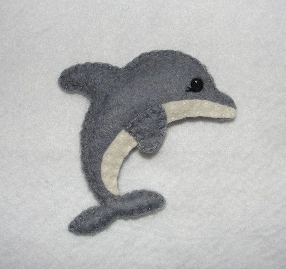 a stuffed dolphin is laying down on the bed with it's tail sticking out