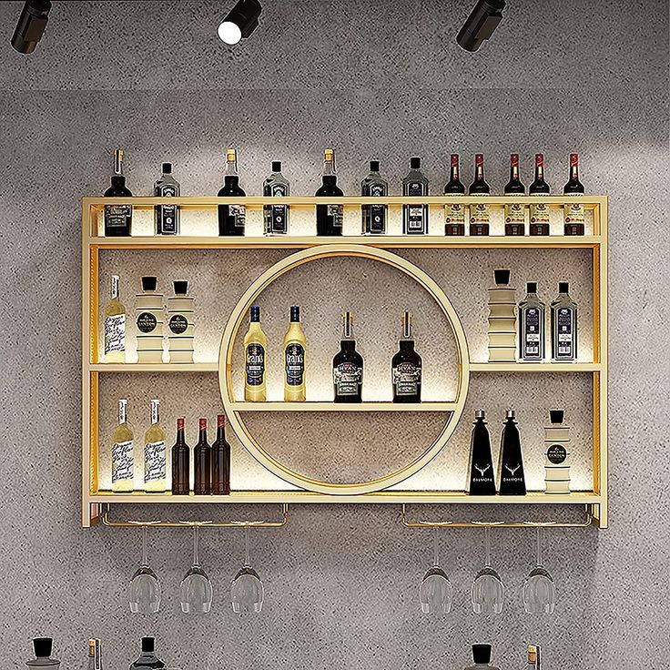 a wine rack filled with lots of bottles and glasses on top of a wall mounted shelf