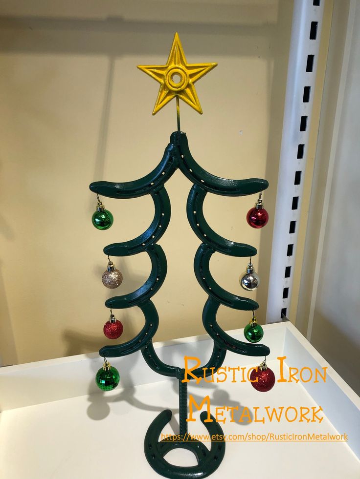 a christmas tree made out of plastic with ornaments hanging from it's top and bottom