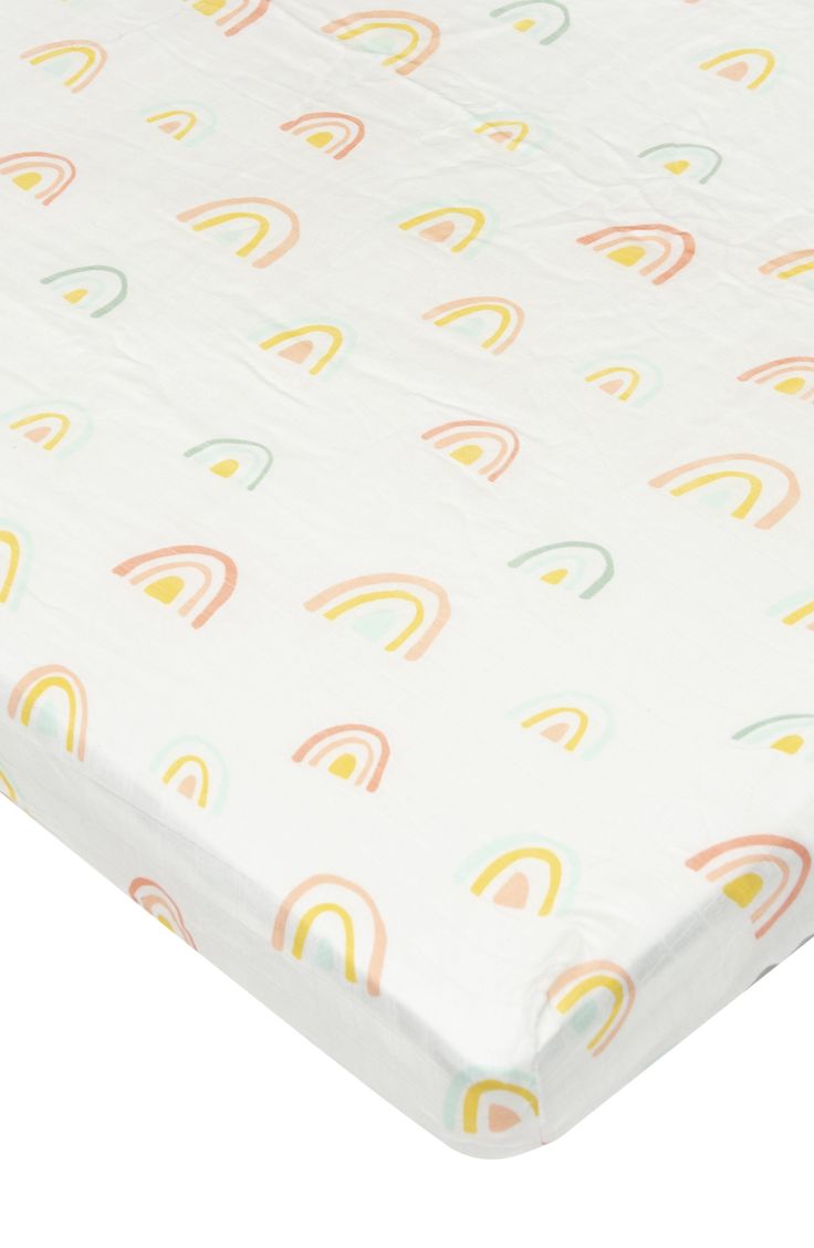 an image of a baby crib sheet with rainbows and clouds on the sheets