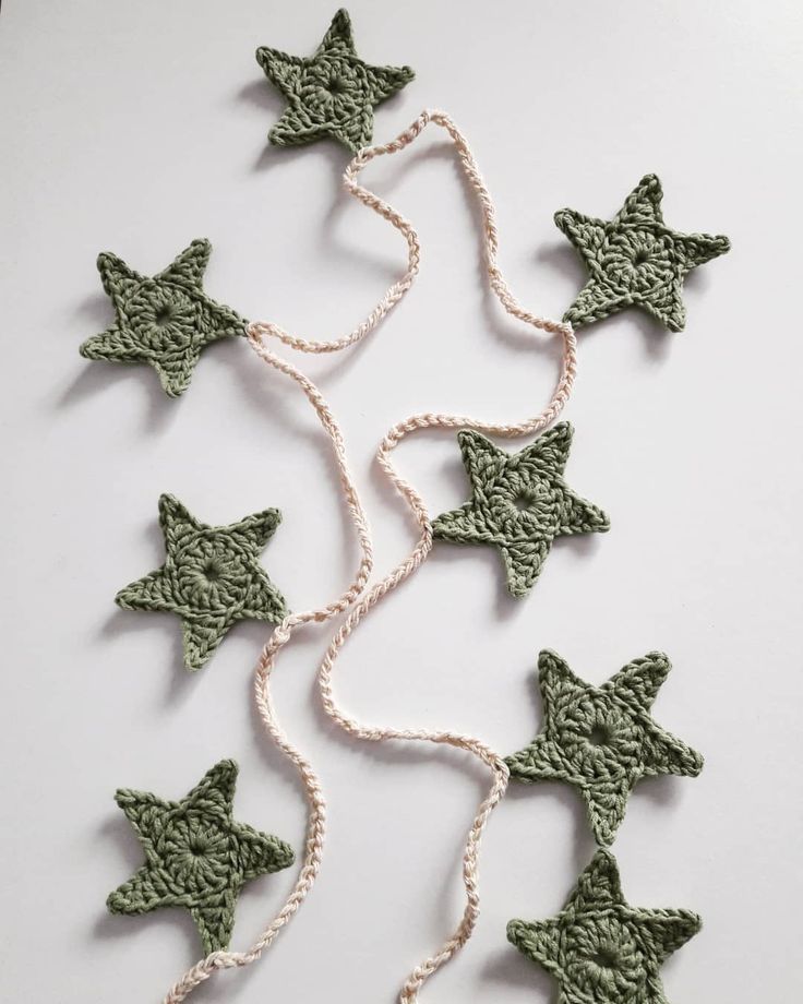 green crocheted stars are hanging from a string