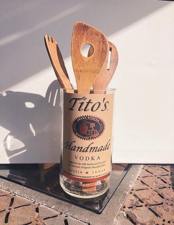 a wooden utensil holder with a bottle and spoon