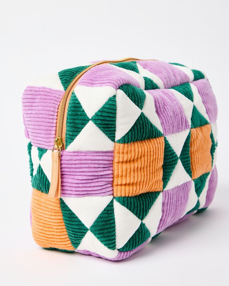 a multicolored cosmetic bag sitting on top of a white table