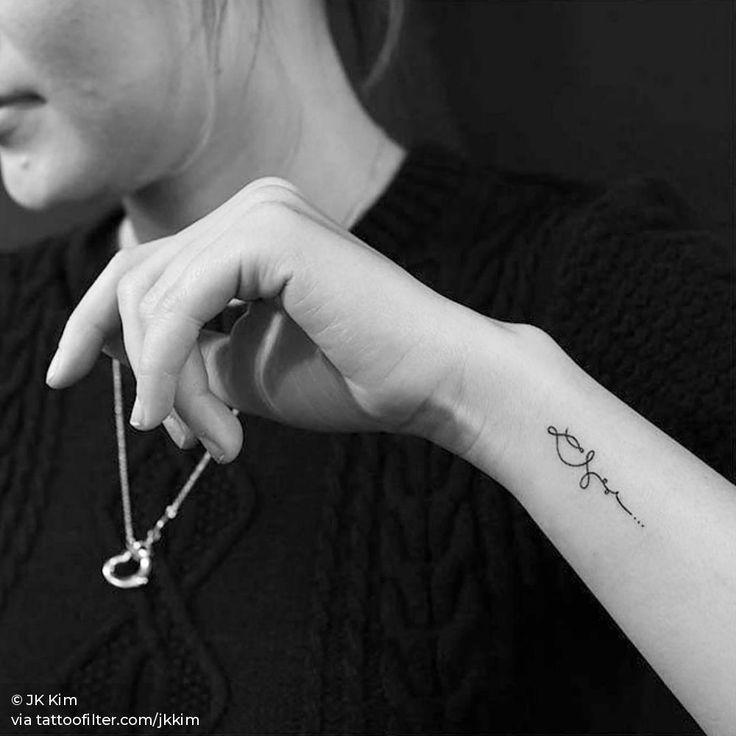 a woman's arm with a small anchor tattoo on the left side of her wrist