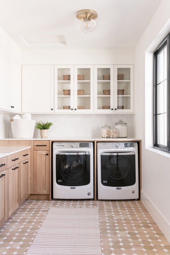 a kitchen with two washers and a dryer in the middle of the room