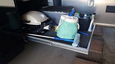 the inside of an rv with its door open and various items on the floor next to it