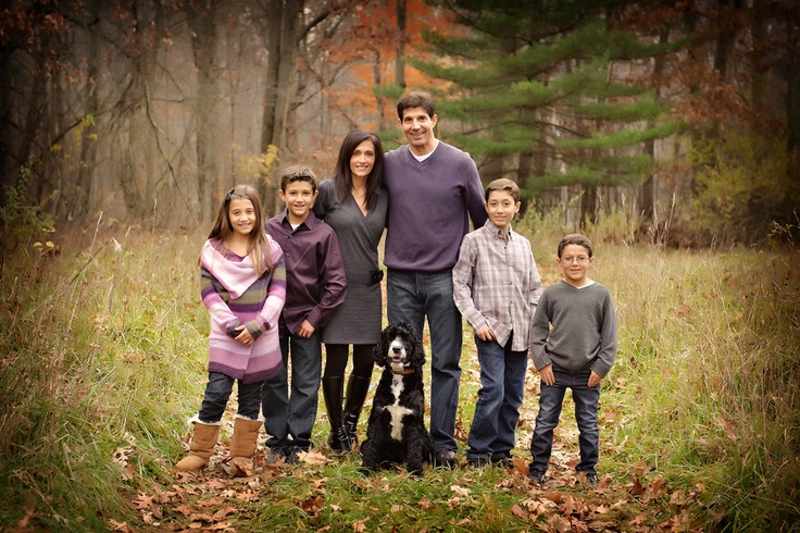 a family posing for a photo in the woods