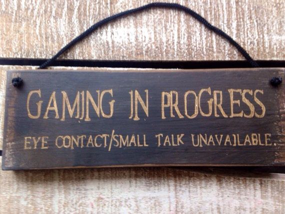 a wooden sign that says gaming in progress eye contact / talk unallable on it