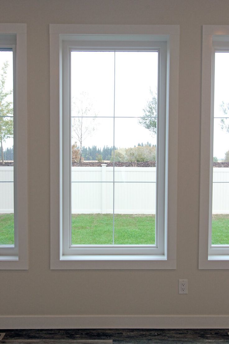 three windows in a room with grass outside