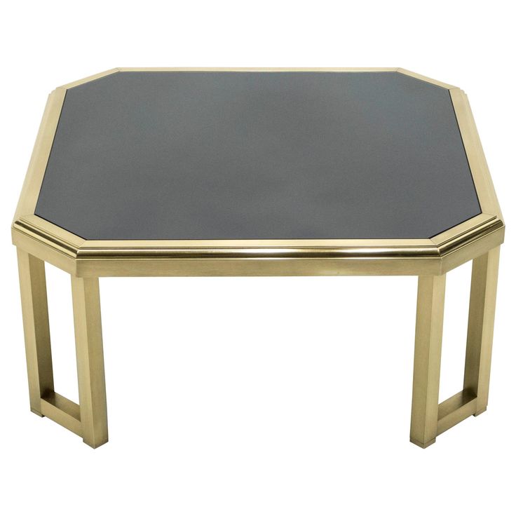 a gold and black glass coffee table with metal legs on an isolated white background for display